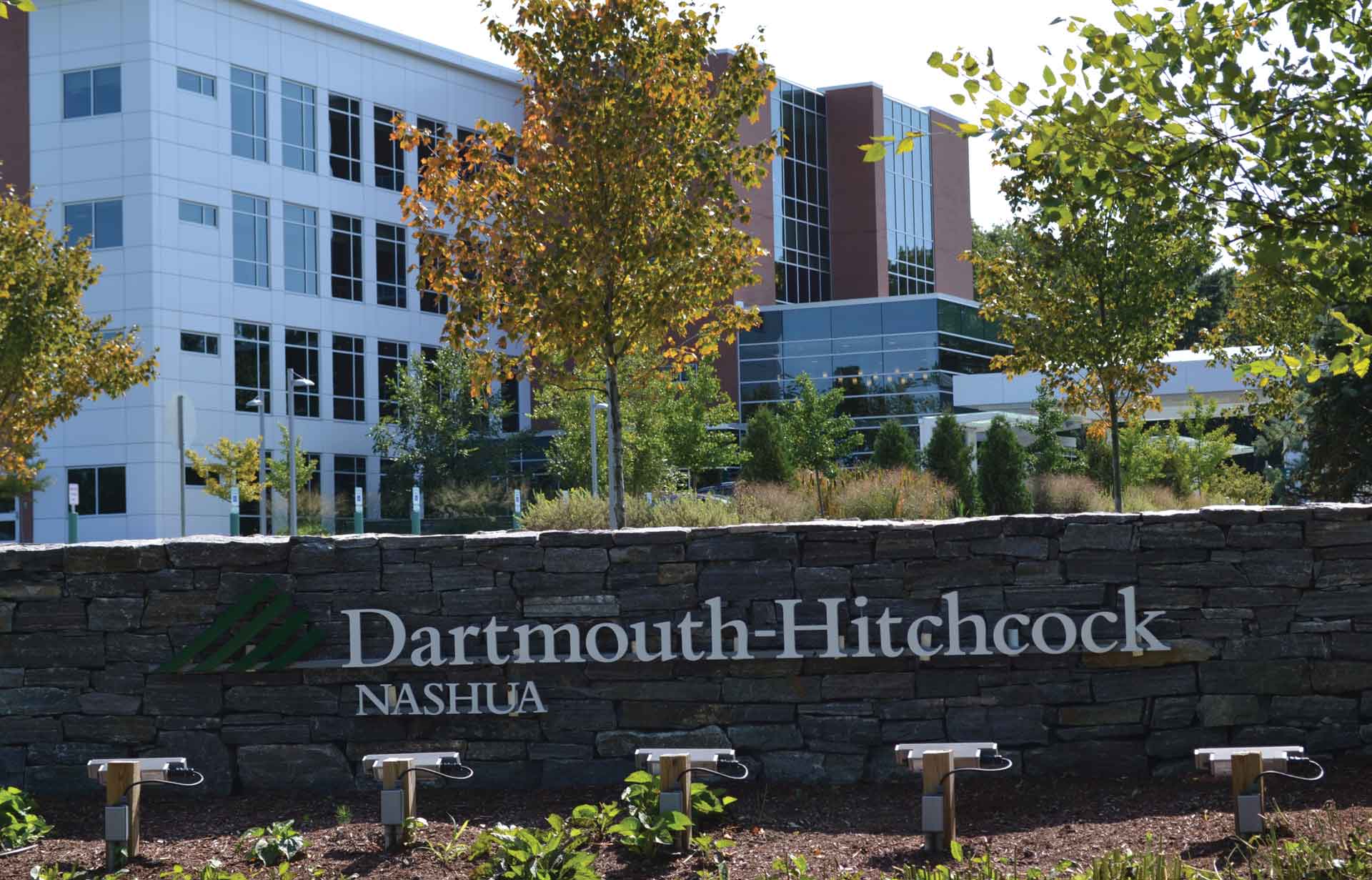 Dartmouth-Hitchcock Nashua building entrance sign with landscaped grounds and trees